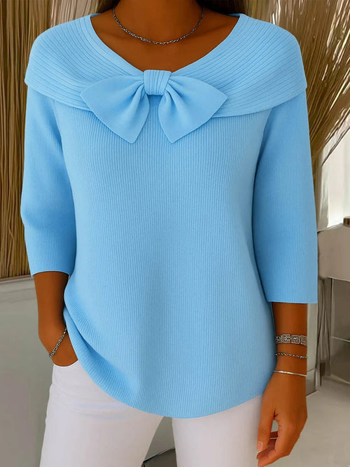 Neeko Blue knit sweater featuring a wide folded collar, oversized bow detail, ribbed texture, three-quarter sleeves, and a relaxed curved hem